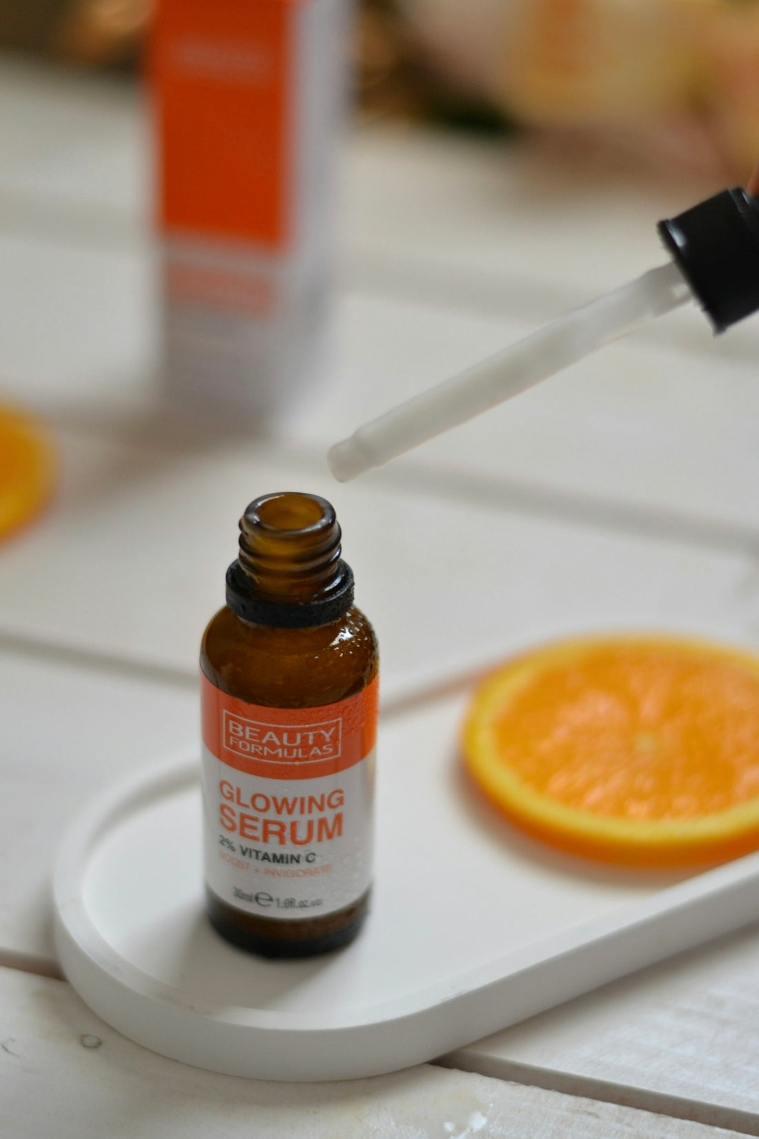 A bottle of vitamin oil sitting on top of an orange