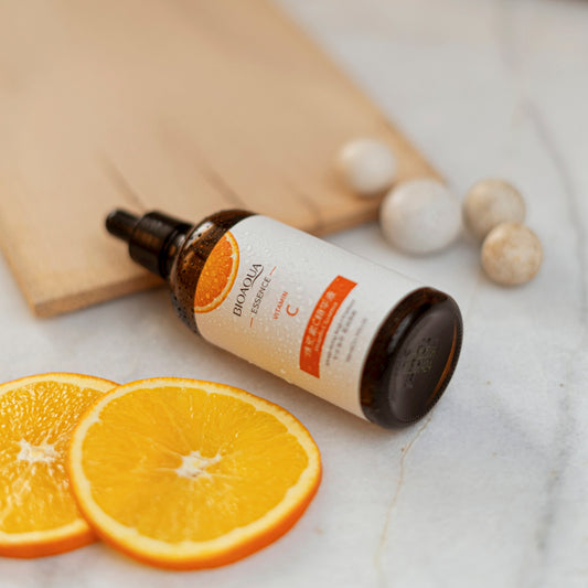 A bottle of vitamin oil sitting on top of an orange